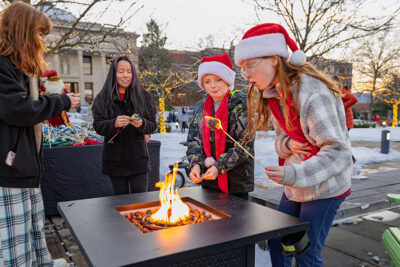 A young girl blows out her flaming marshmallow during the Merry and Bright event at Marywood University in Scranton, PA.