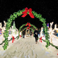 A family walks through a tunnel of Christmas wreaths at the Saint Nick's Display in Waymart, PA.