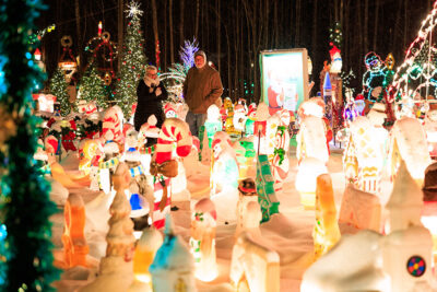 A man an woman admire a plethora of blow molds and other Christmas decorations at the Saint Nick's Display in Waymart, PA.