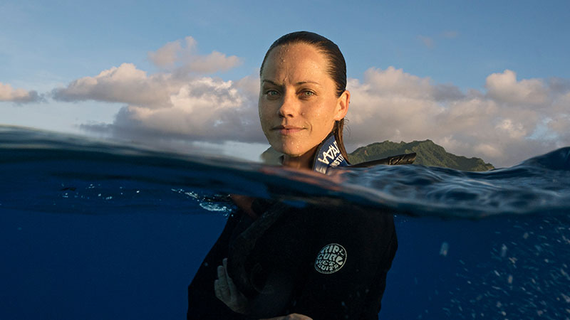 Dr. Jess Cramp partially submerged in ocean water during shark research, featured at the F.M. Kirby Center in Wilkes-Barre, PA.