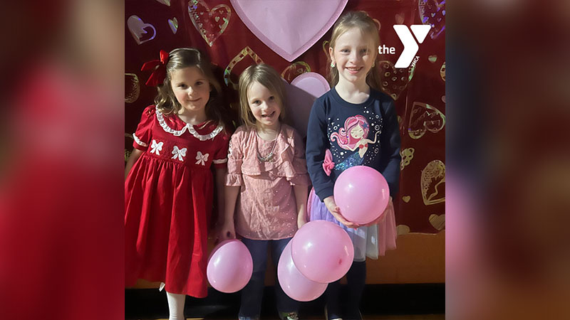 Sweetheart Valentine Dance at Greater Scranton YMCA in Scranton, PA with three girls holding Valentine balloons.