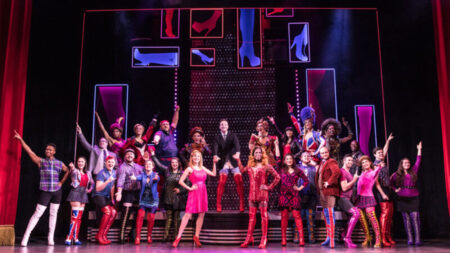 Full cast of Kinky Boots in colorful costumes and red boots in a promotion image for their upcoming Broadway Theatre League performance at the Scranton Cultural Center in Scranton, PA.