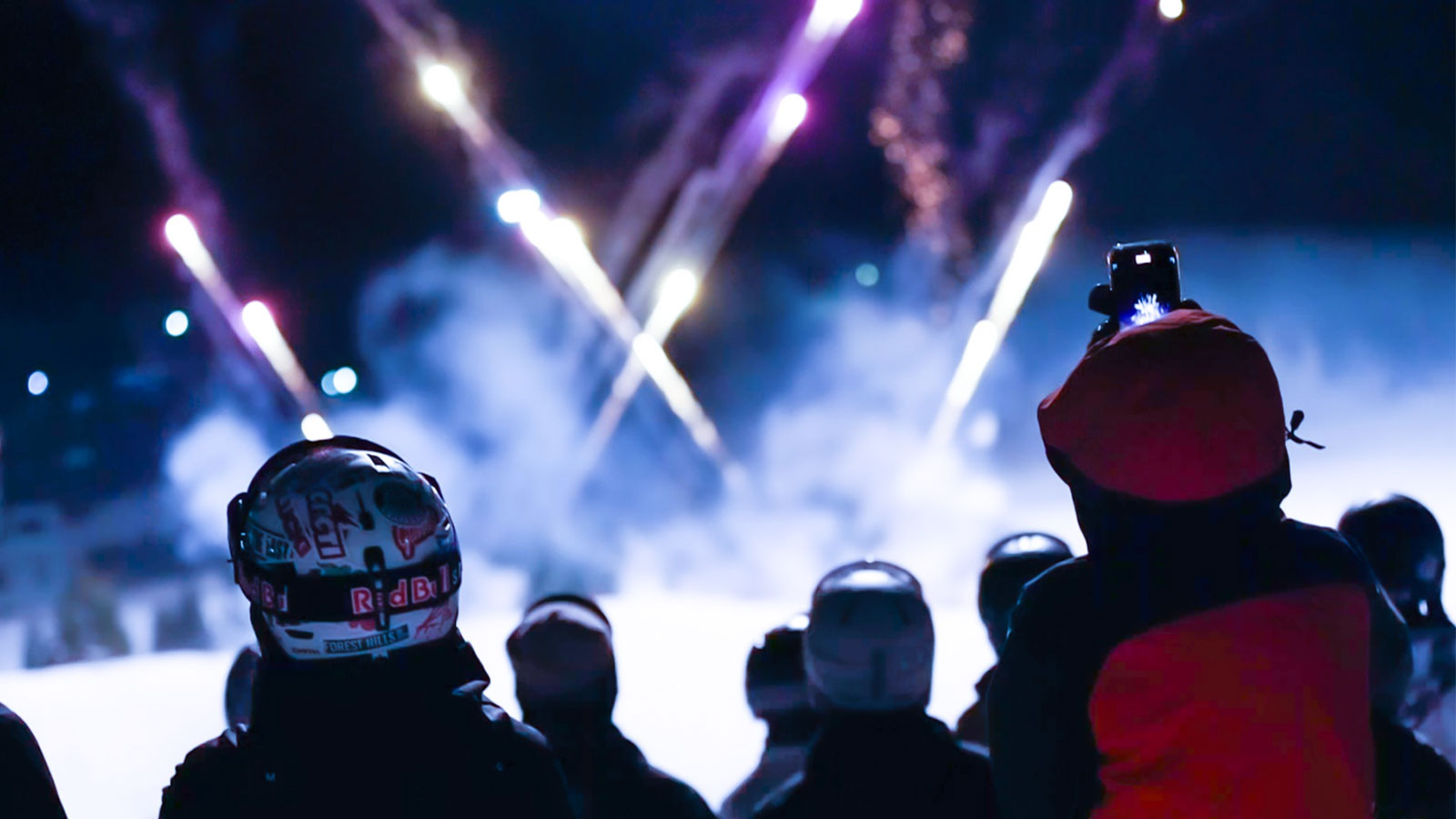 People watching the Torch Light Parade with lights and fireworks in the horizon at Montage Mountain in Scranton, PA.