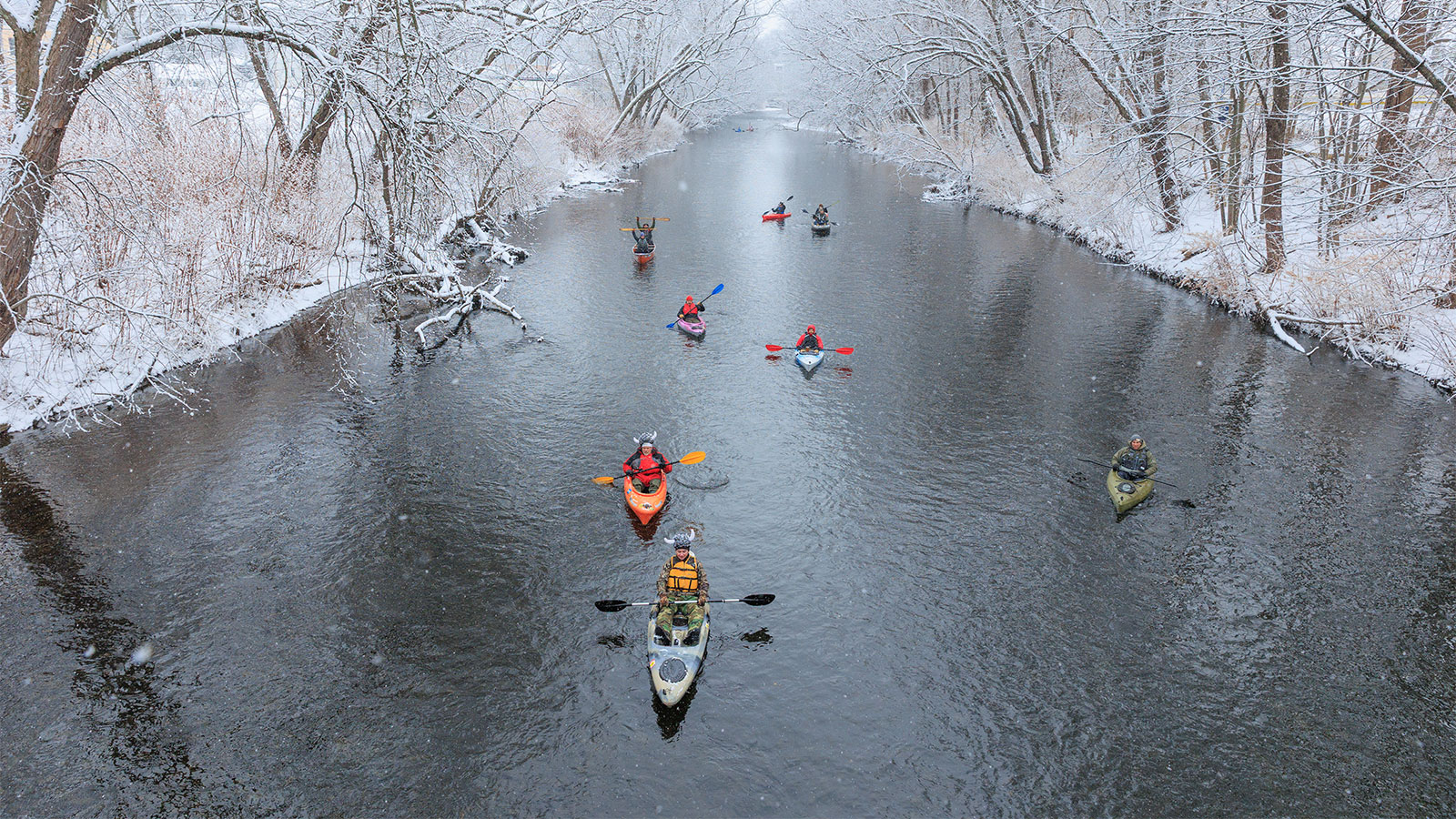 A group of kayakers make their way down snowy Lackawanna River during Shiverfest in Scranton, PA.