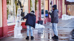 Festival-goers interact with an ice sculpture along a downtown sidewalk during Downtown on Ice in Scranton, PA.