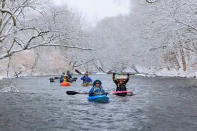 A group of kayakers smile for the camera as they float down the Lackawanna River during Shiverfest in Scranton, PA.