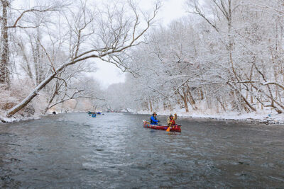 Two canoers lead the way down the Lackawanna River during Shiverfest in Scranton, PA.