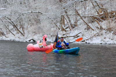 A kayaker dressed in a George Washington costume floats down the Lackawanna River in his kayak with an inflatable flaming tied to his boat during Shiverfest in Scranton, PA.