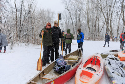 A father and son pose for the camera while holding oars next to their canoe during Shiverfest in Scranton, PA.