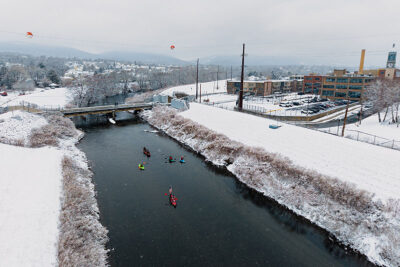 An aerial view of kayakers paddling under the Albright Street bridge during Shiverfest in Scranton, PA.