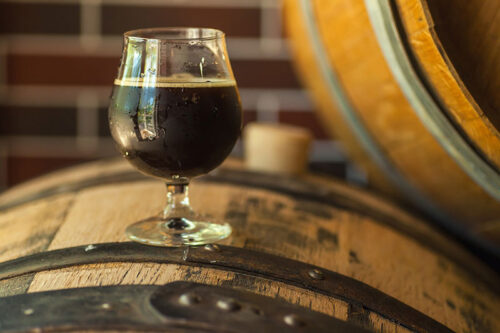 A dark beer sits on top of a whiskey barrel at ShawneeCraft Brewing Company in Shawnee on Delaware, PA.