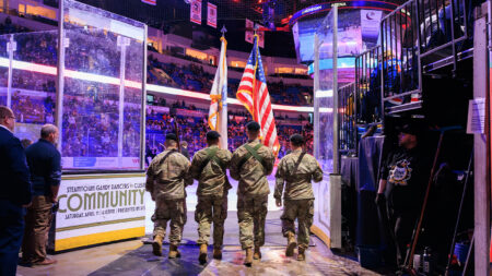 Men in US Military uniform proceed out to the ice holding flags at the WIlkes-Barre/Scranton Penguins game in Wilkes-Barre, PA.