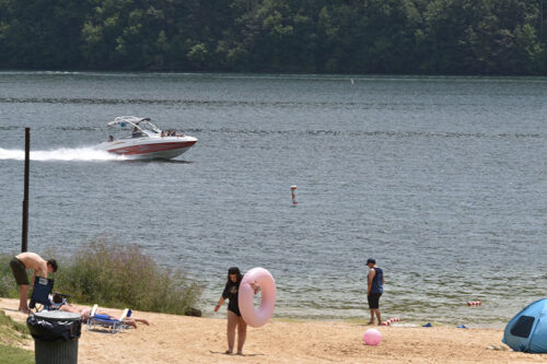Children prepare to enter the lake as a boat cruises by at Beltzville State Park in Lehighton, PA.