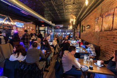 Crowds fill a restaurant dining room with exposed brick walls during Celebrate Music in Pittston, PA.