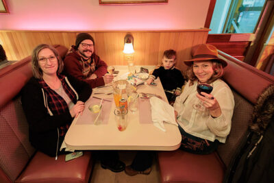 Two women, one man, and one child sit at a booth inside a restaurant during Celebrate Music in Pittston, PA.
