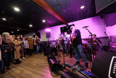 A live band performs on stage in front of an audience during Celebrate Music in Pittston, PA.