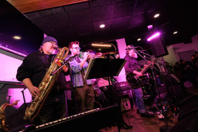 A band performs on stage with microphones and instruments during Celebrate Music in Pittston, PA.