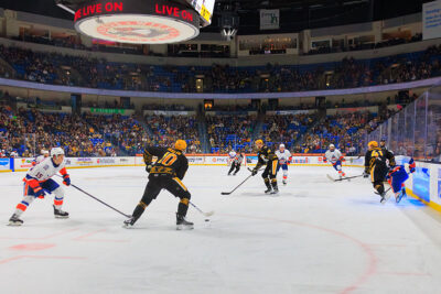 A hockey player is about to pass the puck to a teammate at the WIlkes-Barre/Scranton Penguins game in Wilkes-Barre, PA.