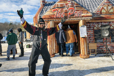 A man poses in front of The Pub tent at Wally Ice Fest in Newfoundland, PA.