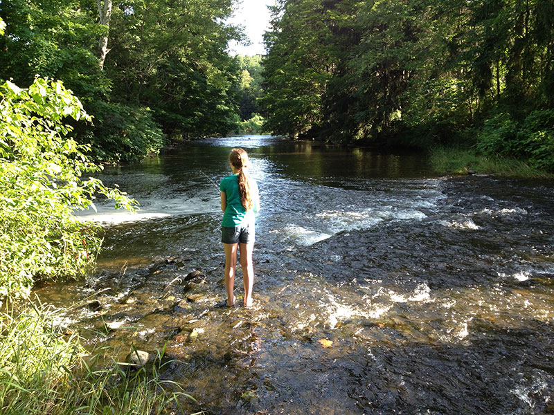 A young girl casts a line into Tunkhannock Creek in Factoryville, PA.