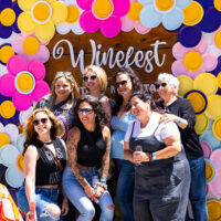 Spring Winefest at Montage Mountain in Scranton, PA photo of attendees posing in front of colorful “Winefest” backdrop