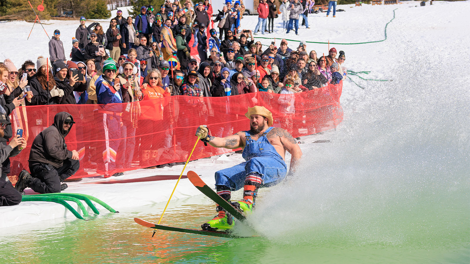 A man dressed as a farmer glides across the water on his skis at Mountainfest at Montage Mountain in Moosic, PA.