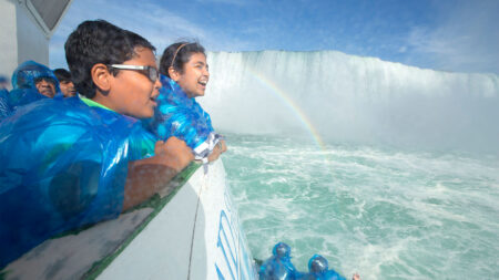 Kids overlooking the falls and water from the Maid of The Mist boat tour at Niagara Falls.