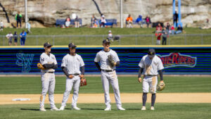 Four RailRiders baseball players standing on the field mid-game on opening day at PNC Field in Moosic, PA.