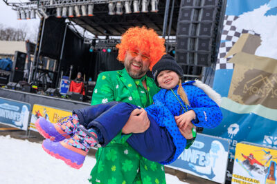 A man dressed as a leprechaun holds his daughter and smiles for the camera at Mountainfest at Montage Mountain in Moosic, PA.