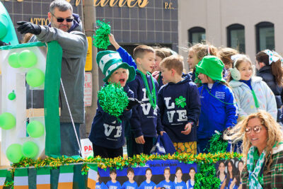 A boy on the back of a flatbed truck points to the camera during the St. Patrick's Day parade in Scranton, PA.