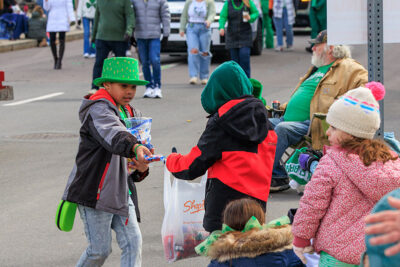 A boy gives another boy a piece of candy during the St. Patrick's Day parade in Scranton, PA.