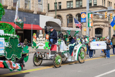 A man in an old fashioned carriage waves to the crowd during Scranton's St. Patrick's Day parade.