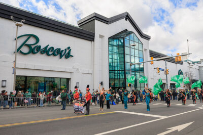 A group of dances make their way down the street in front of Boscov's retail store during the St. Patrick's Day parade in Scranton, PA.