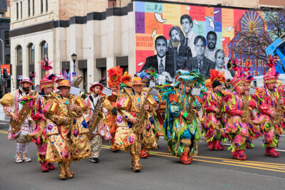 A highly colorful group plays instruments while walking down the street during the St. Patrick's Day parade in Scranton, PA.