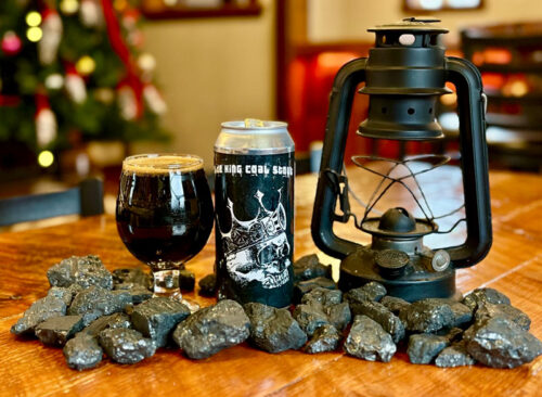 A pint of stout, a can and an old coal mine lantern on a table at Breaker Brewing Company in Wilkes-Barre Twp., PA.