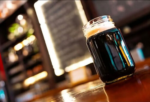 A pint of stout in a mason jar glass on the bar at Here & Now Brewing Company in Honesdale, PA.