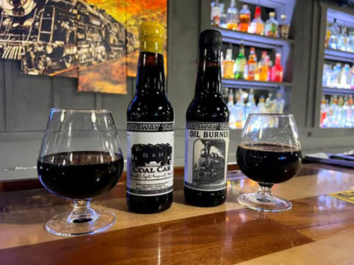Two bottles and two glasses of stout on the bar at Runaway Train Brewery in Honesdale, PA.