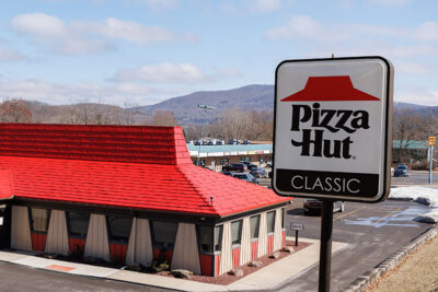 A Pizza Hut Classic sign stands tall outside with the restaurant behind it at Pizza Hut Classic in Tunkhannock, PA.