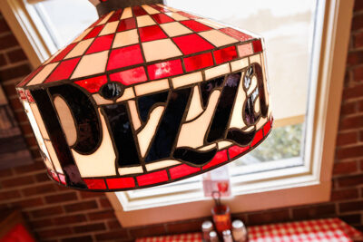 A close up of the red and white glass lamp shade with the word 