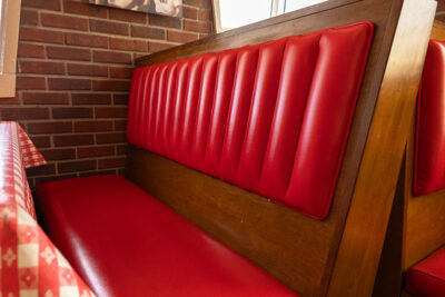 A nostalgic wooden booth with red padding at Pizza Hut Classic in Tunkhannock, PA.