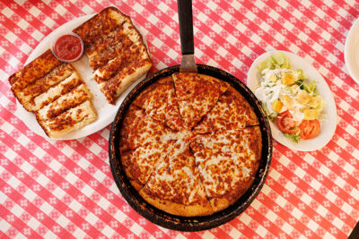 An overhead view of cheesy breadsticks, pizza, and a salad at Pizza Hut Classic in Tunkhannock, PA.