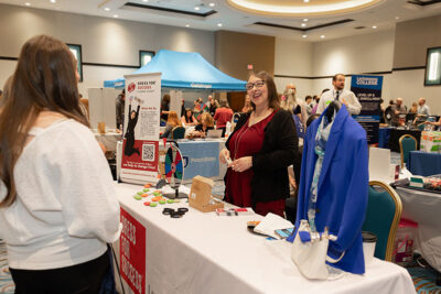 A representative from Dress for Success smiles at a student during a career exploration event at the Mohegan Pennsylvania Convention Center in Wilkes-Barre, PA.