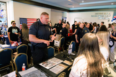 A law enforcement officer speaks with students at an interactive public safety exhibit during a career exploration event at the Mohegan Pennsylvania Convention Center in Wilkes-Barre, PA.
