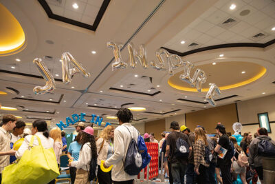 Balloons hang overhead reading 