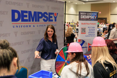 A representative from Dempsey Uniform and Linen Supply speaks with students during a career exploration event at the Mohegan Pennsylvania Convention Center in Wilkes-Barre, PA.